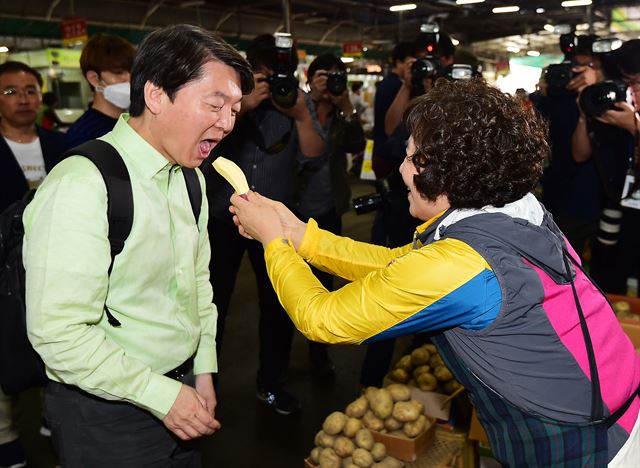 안철수 국민의당 대선 후보가 6일 광주 북구 각화동 농산물 도매시장에서 상인이 건넨 고구마를 먹고 있다. 광주=뉴스1