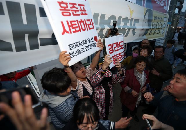 지난달 21일 경주역 앞 광장에서 홍준표 자유한국당 대선후보가 집중유세를 끝내자 시민단체 회원들이 홍 후보의 사퇴를 촉구하다 경호원들에게 저지 당하고 있다. 홍 후보는 지난 자서전에서 대학시절 친구가 돼지발정제로 여성을 해하려한 일이 있다고 밝힌 사실이 최근 알려져 파문이 일었다. 연합뉴스