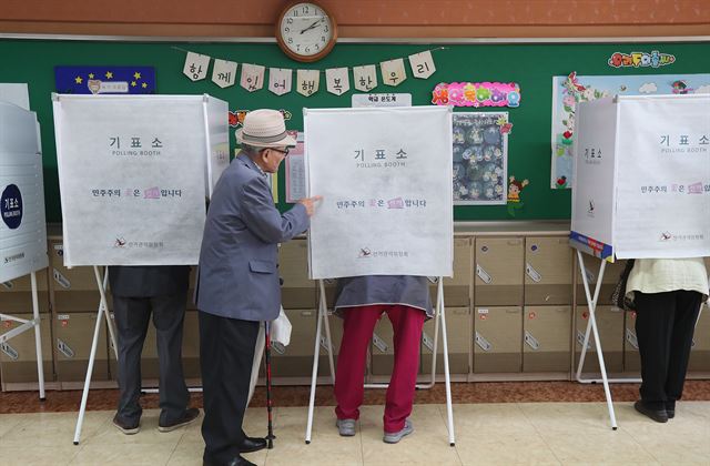 제19대 대통령선거일인 9일 오후 서울 종로구 가회동 투표소가 마련된 재동초등학교에서 사전투표를 한 어르신이 부인이 기표하는 동안 기다리고 있다. 연합뉴스