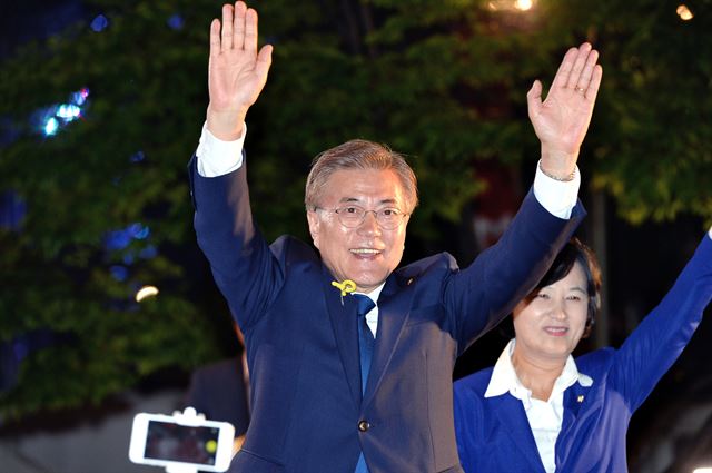 문재인 대통령 당선인이 9일 밤 서울 종로구 세종로공원에서 열린 시민들과 함께하는 개표 방송에서 추미애 더불어민주당 대표와 함께 지지자들을 향해 손을 흔들고 있다. 왕태석 기자