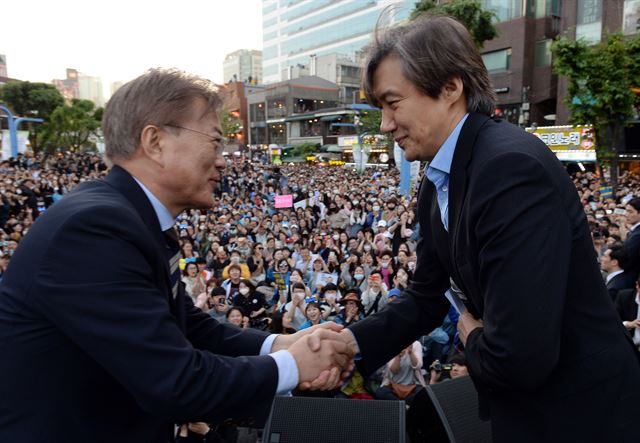 더불어민주당 문재인 대선후보가 6일 오후 서울 마포구 홍대입구역 인근에서 열린 '투표참여 릴레이 버스킹 vote0509'행사에서 조국 서울대 법학전문대학원 교수와 악수하고 있다. 연합뉴스