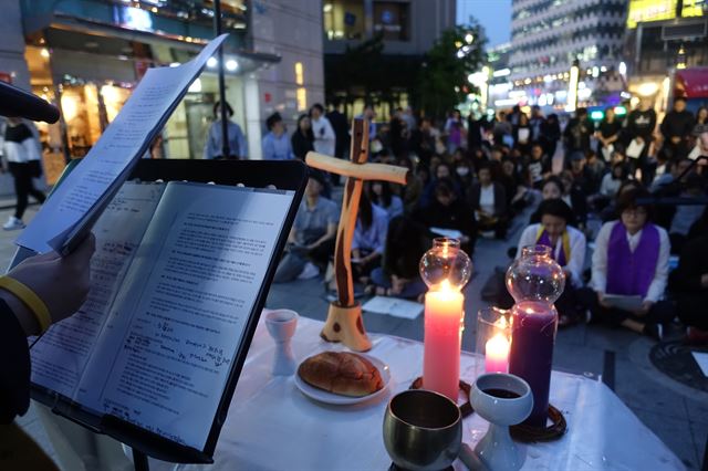 지난 11일 서울 강남역 10번출구 앞에서 열린 강남역 여성혐오범죄 희생자 1주기 추모예배 '살아남아,다시 붙인다'가 열리는 가운데 믿는페미의 활동가가 현장의 기도를 진행하고 있다.