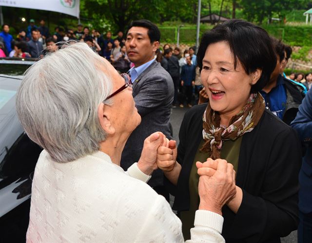 영부인 김정숙 여사(오른쪽)가 13일 오후 서울 서대문구 홍은동 사저에서 청와대로 떠나기 전 입구에서 기다리던 시민들과 인사를 나누고 있다. 연합뉴스