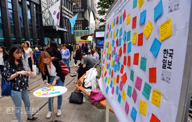 한국일보가 ‘강남역 살인사건 1주기’를 앞두고 지난 12일 서울 강남역 10번 출구 앞에 차린 부스에서 시민들이 우리 사회 여성혐오에 대한 문제의식을 포스트잇에 자유롭게 담고 있다. 류효진기자