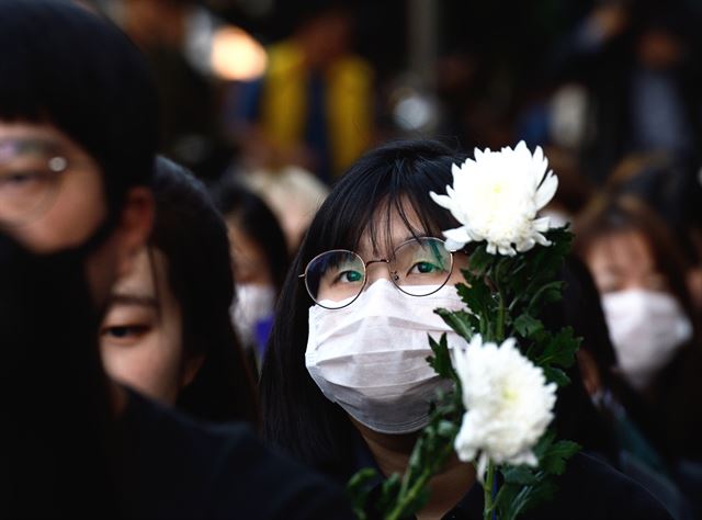 강남역 ‘여성 살해’ 사건 1주기인 17일 저녁 서울 신논현역 인근에서 열린 추모 문화제에서 참가자들이 추모시 낭송을 들으며 슬픈 표정을 짓고 있다