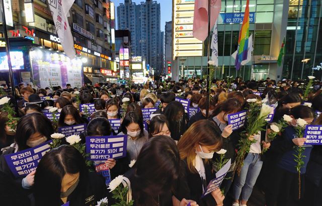 강남역 ‘여성 살해’ 사건 1주기인 17일 저녁 서울 신논현역 인근에서 열린 추모 문화제에 참여한 법페미니스트 회원들과 시민들이 사건현장을 방문해 묵념을 하고 있다.