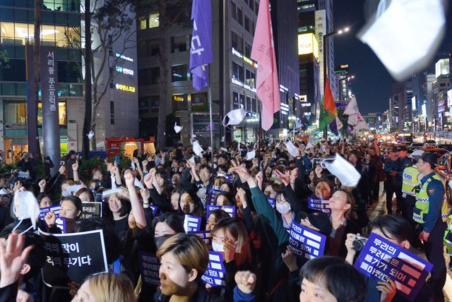 그림 4 범페미니스트워크 등 여성단체회원들이 17일 저녁 신노현역 부근에서 강남역 여성혐오 살인 사건 1주기를 맞아 추모제를 연 후 강남역 10번 출구에서 마스크를 벗어 던지는 퍼포먼스를 하고 있다.