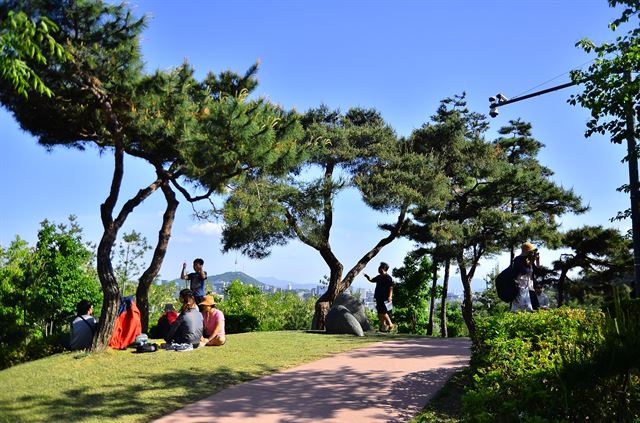 자하문고개 '윤동주 시인의 언덕'에서 동네 주민들이 모여 이야기하고 있다. 저 멀리 남산을 비롯한 서울도심이 내려다 보인다.