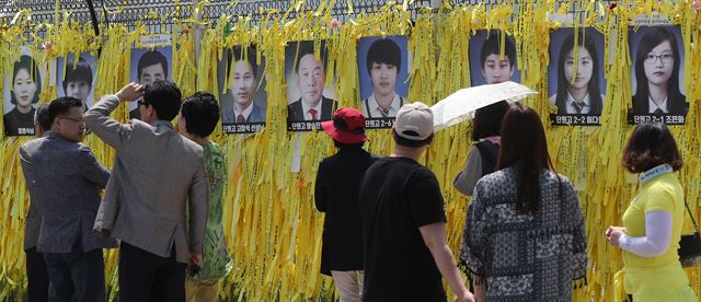 지난 16일 세월호가 거치된 전남 목포신항에서 추모객들이 미수습자들의 사진을 바라보고 있다. 목포=연합뉴스