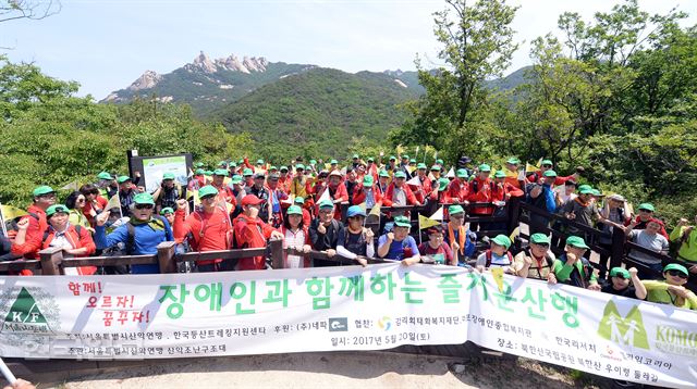 서울마포장애인종합복지관 장애우들이 서울시산악연맹 소속 산악구조대원들의 도움으로 20일 오전 서울 북한산 우이령 둘레길 산행을 하며 기념촬영을 하고 있다.배우한기자