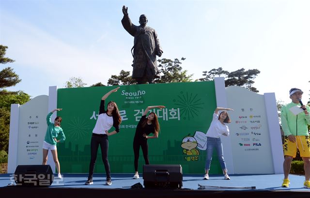 제465회 한국일보 거북이마라톤 '서울로 7017 보행길 개통 기념 걷기대회' 행사가 21일 오전 서울 남산 백범공원에서 열린 가운데 사회자 김종덕씨와 2016 미스코리아들이 출발에 앞서 체조를 하고 있다. 홍인기 기자