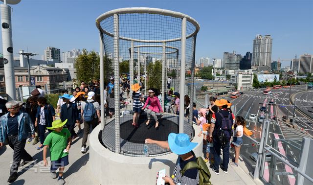 제465회 한국일보 거북이마라톤 '서울로 7017 보행길 개통 기념 걷기대회' 행사가 21일 오전 서울 남산 백범공원에서 열린 가운데 어린이 참가자들이 서울역고가 보행길의 방방놀이터에서 점프를 하고 있다. 홍인기 기자