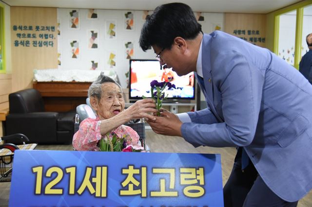 이근규(오른쪽)제천시장이 21일 경기 구리시의 한 요양원을 찾아 국내 최고령자인 김엄곡 할머니에게 제천 명예시민패와 카네이션을 전달했다. 제천시 금성면에서 태어난 김 할머니는 77세까지 제천에서 살았다. 제천시 제공