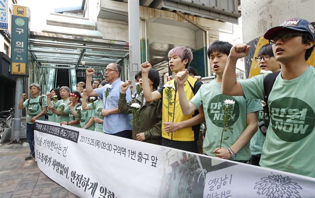 25일 오전 서울 광진구 지하철 2호선 구의역 1번 출구 앞에서 열린 구의역 스크린도어 사고 1주기 추모 기자회견에서 전국민주노동조합총연맹(민주노총) 만원행동 관계자들이 구호를 외치고 있다. 2017.5.25 서울=연합뉴스