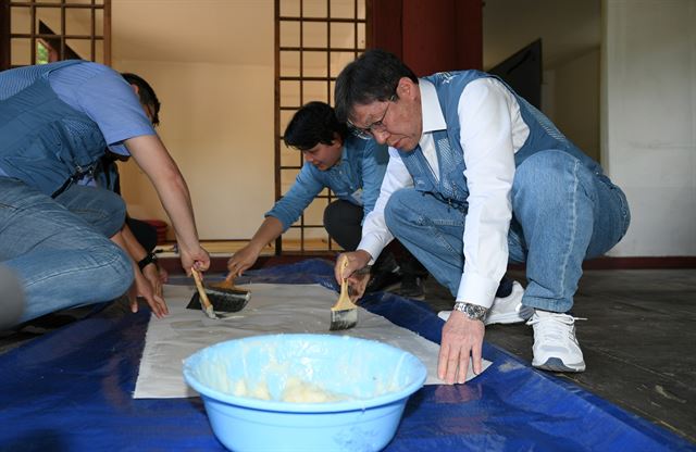 권오준(오른쪽) 포스코 회장과 직원들이 30일 서울 종로구 성균관 명륜당의 창문과 문짝의 낡은 창호지를 교체하고 있다. 포스코 제공