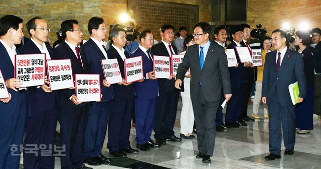 자유한국당 의원들이 31일 오후 국회 본회의장 입구에서 이낙연 국무총리 후보자의 사퇴를 촉구하며 피켓 시위를 벌이고 있는 가운데 의원총회를 마친 우원식 더불어민주당 원내대표가 본회의장으로 입장하고 있다. 배우한 기자