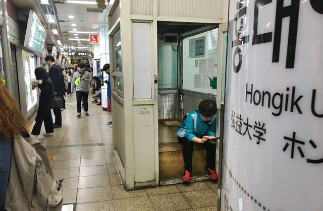 막간의 휴식시간을 이용해 스마트폰을 확인하고 있는 청소노동자. 교대로 식사를 하는 시간엔 이마저도 사치다.