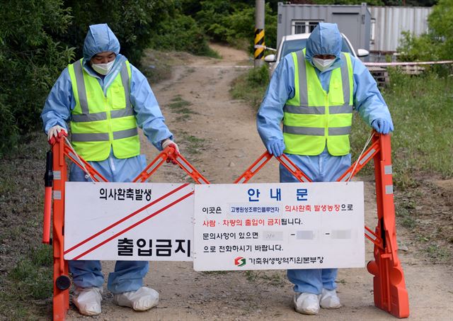 4일 오후 조류인플루엔자(AI) 양성 반응이 나온 경기 파주시 법원읍 한 농장앞에 방역 당국 관계자들이 외부인의 출입을 통제하고 있다. 연합뉴스