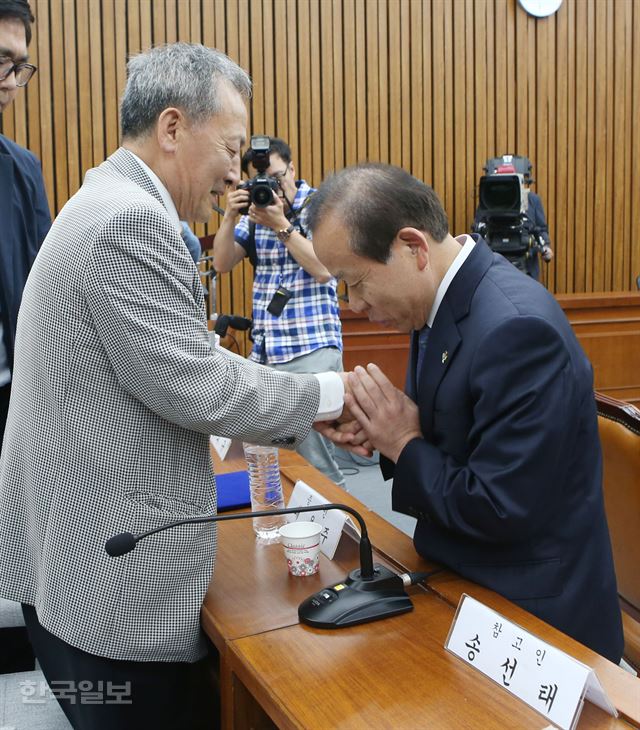 김이수 헌법재판소장 후보자(오른쪽)가 8일 오후 국회에서 열린 인사청문회에서 5ㆍ18 당시 사형판결을 내린 버스운전기사 배용주(증인참석)씨의 손을 잡고 대화를 마치며 인사하고 있다. 오대근 기자