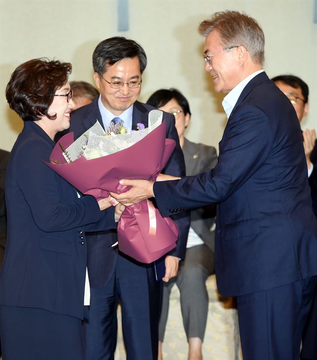 문재인 대통령이 9일 청와대에서 김동연 경제 부총리에게 임명장을 수여한 뒤 부인 정우영씨에게 꽃다발을 전달 하고 있다. 고영권기자