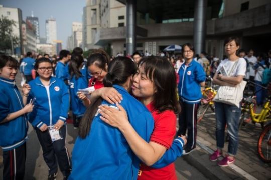 지난 7일 중국 베이징에서 한 교사가 가오카오를 치르는 제자를 껴안으며 응원하고 있다. 베이징=EPA 연합뉴스