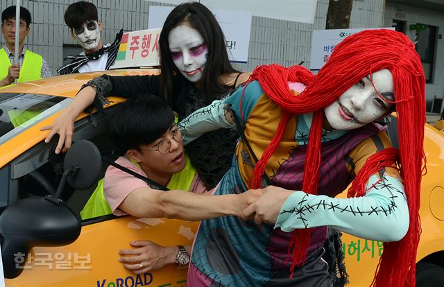 13일 서울 마포구 상암동 서부면허시험장에서 좀비 복장을 한 모델들이 '졸음운전 예방캠페인'에서 졸음 운전자를 끌고 가는 퍼포먼스를 하고 있다. 이 캠페인은 여름 휴가철을 앞두고 매년 100여 명씩 사망하는 졸음운전에 대한 경각심을 높이기 위해 마련됐다. 2017.6.13신상순 선임기자 ssshhin@hankookilbo.com