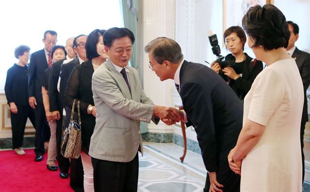 문재인 대통령이 부인 김정숙 여사와 함께 15일 청와대 영빈관에서 '국가유공자 및 보훈 가족과의 따뜻한 오찬' 행사에서 입장하는 참석자들과 인사를 나누고 있다. 연합뉴스