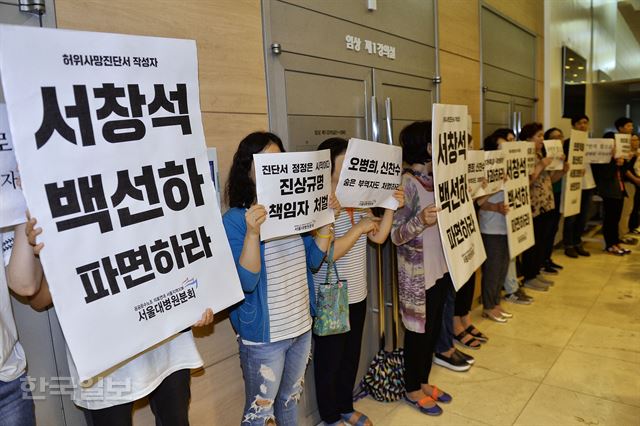 서울대병원 노조관계자들이 지난 15일 서울 연건동 서울대학교병원에서 열린 고 백남기 농민 사망 관련 긴급기자회견장 밖에서 ‘유가족과 국민에게 사과하라’는 피켓을 들고 구호를 외치고 있다. 류효진기자 jsknight@hankookilbo.com