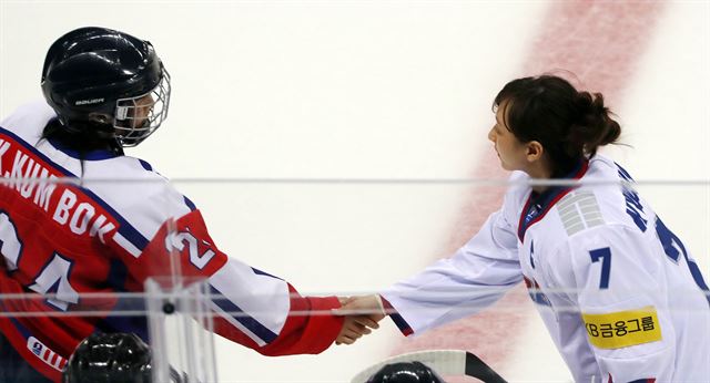 지난 4월 강릉에서 열린 2017 IIHF 아이스하키 여자 세계선수권대회 디비전Ⅱ 그룹 A 대회 한국과 북한의 경기에 앞서 북한 김금복(왼쪽)과 한국 이규선이 기념품을 교환하며 악수를 하고 있다. 연합뉴스