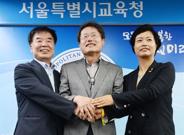 조희연 서울시교육감(왼쪽 두번째)과 전병식 서울교총 회장(왼쪽), 김해경 전교조 서울지부장이 22일 서울 종로구 서울시교육청에서 진행한 기자회견 직후 손을 맞잡고 있다. 뉴시스