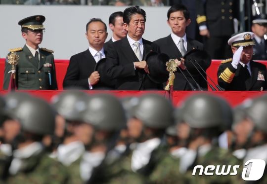 아베 신조(가운데) 일본 총리가 지난해 10월 육상자위대 아사카 주둔지에서 행진하는 자위대원들을 지켜보고 있다. AFP 뉴스1