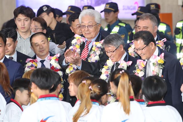 북한의 장웅 국제올림픽위원회(IOC) 위원이 국제태권도연맹(ITF)시범단을 이끌고 23일 오후 김포공항을 통해 입국, 환영 나온 세계태권도연맹(WTF) 어린이시범단을 향해 박수치고 있다. 연합뉴스