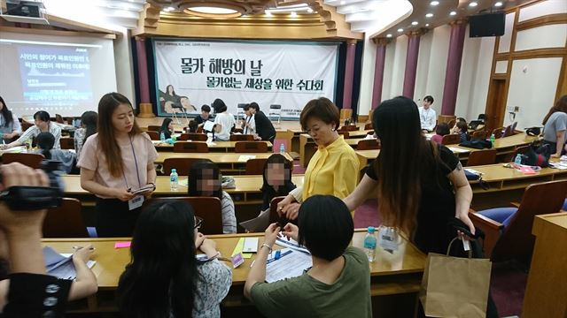 지난 23일 오후 국회의원회관에서 진선미의원실, 와글, DSO, 국회시민사회포럼 공동 주최로 열린 '몰카 해방의 날: 몰카없는 세상을 위한 수다회'에서 진선미 의원과 참석자들이 몰카 범죄 규제에 대한 입법 아이디어를 함께 논의하며 소형 몰카 장비들을 살펴보고 있다.