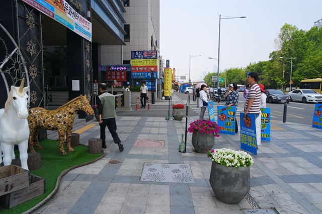 17일 오전 서울 용산 화상경마장 앞에서 용산화상경마도박장추방대책위원들이 시위를 진행하는 가운데 한 입장객이 서둘러 걸음을 옮기고 있다. 전혼잎 기자