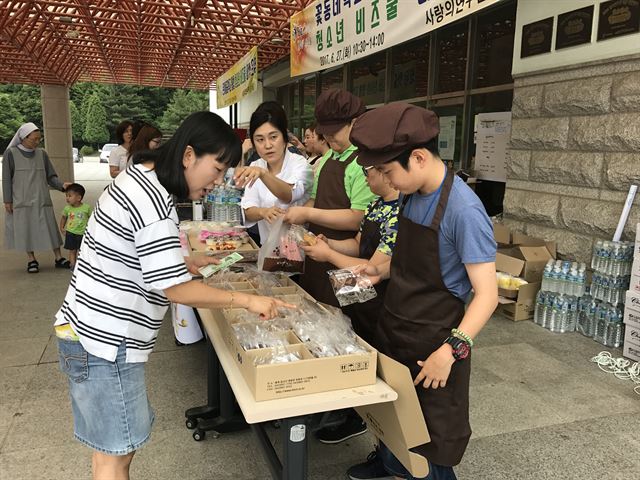 꽃동네학교와 은여울중학교 학생들이 27일 음성 꽃동네 사랑의연수원 앞 마당에 비즈쿨 마켓을 차리고 손수 만든 공예품 등을 판매하고 있다. 꽃동네학교 제공