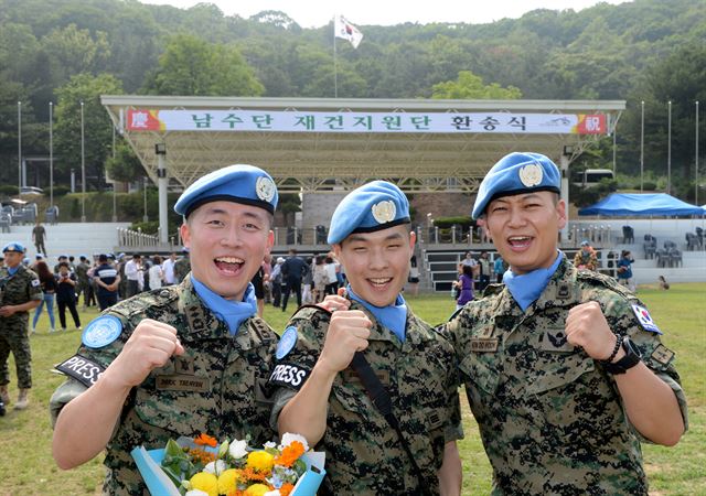 28일 오후 인천시 계양구 국제평화지원단에서 열린 '한빛부대 8진 환송식'에서 공보를 담당한 정훈공보과장 김도훈(오른쪽) 소령, 공보장교 박태현(왼쪽) 대위, 공보병 방찬우 상병이 파이팅을 외치고 있다. 인천=홍인기 기자