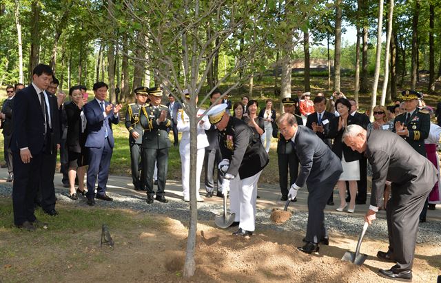 문재인 대통령이 28일(현지시간) 미국 버지니아주 콴티코 국립해병대박물관 경내에서 로버트 넬러(왼쪽) 미 해병대 사령관, 장진호 전투 참전용사인 스티븐 옴스테드 예비역 미 해병대 중장(오른쪽)과 함께 산사나무를 심고 있다. 콴티코=고영권 기자