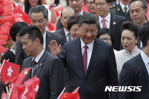 시진핑 중국 국가주석이 29일 부인 펑리위안 여사와 함께 홍콩 반환 20주년 기념행사에 참석하기 위해 홍콩국제공항에 도착한 뒤 환영인사에 손을 흔들어 답하고 있다. 홍콩=AP 뉴시스