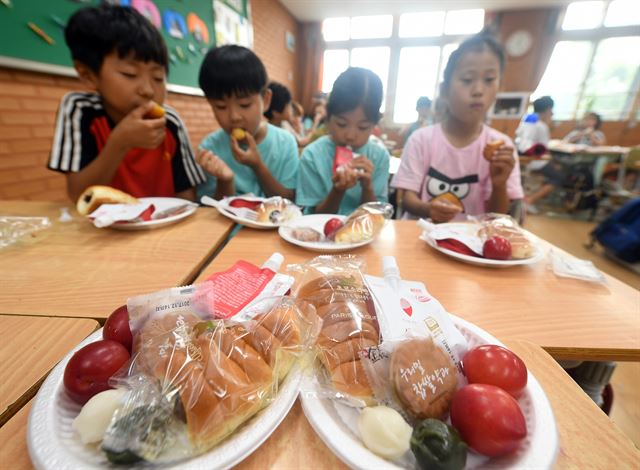 전국 학교비정규직노조 파업 첫날인 지난 29일 서울 연무초등학교에서 학생들이 학교 측에서 준비한 빵, 우유 등을 먹고 있다. 배우한 기자 bwh3140@hankookilbo.com