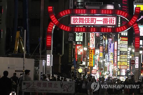 도쿄도(東京都) 신주쿠(新宿)구 가부키초(歌舞伎町)의 유흥업소 밀집지구 입구에서 행인들이 길을 건너려고 기다리고 있다. 도쿄=연합뉴스 자료사진