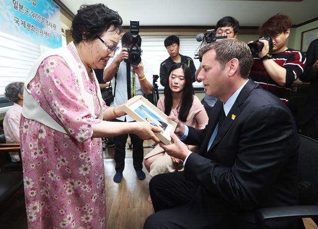 일본군 위안부 피해자 이용수 할머니가 5일 경기 광주시 나눔의 집을 방문한 에드워드 브라운스타인 미국 뉴욕주 하원의원에게 고 김순덕 할머니가 그린 그림 ‘끌려감’을 선물하고 있다. 연합뉴스