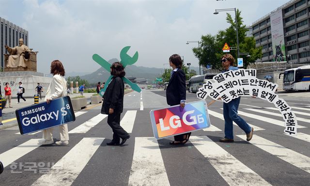 록그룹 비틀스로 분장한 국제환경단체 그린피스 활동가들이 스마트폰 제조사 로고를 들고 5일 오전 서울 광화문 앞 횡단보도를 건너고 있다. 신상순 선임기자ssshin@hankookilbo.com /2017-07-05(한국일보)