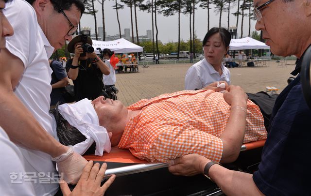 [저작권 한국일보] 대한적십자사 봉사자들이 6일 오전 서울 월드컵공원 평화광장에서 재난대응훈련을 열고 국지성 폭우로 인한 대량 이재민 발생 상황을 가정, 응급환자를 이송하는 훈련을 하고 있다. 2017.7.6 / 류효진기자 /2017-07-06(한국일보)