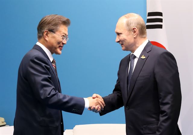 문재인(왼쪽) 대통령이 지난 7일 오후 독일 함부르크 G20 메세홀 내 양자회담장에서 블라디미르 푸틴 러시아 대통령을 만나 악수하고 있다. 함부르크=연합뉴스