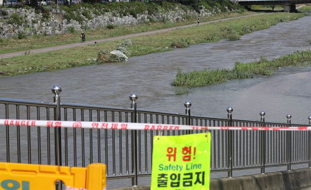 11일 오전 강원 춘천시 도심 공지천이 전날 폭우로 불어나 인근 산책로까지 물이 범람해 있다. 연합뉴스