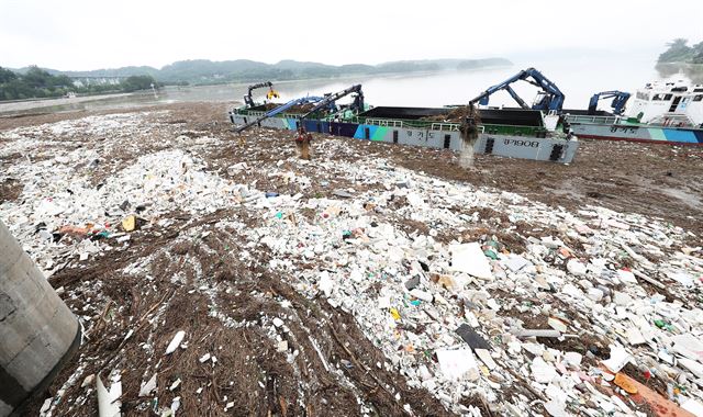 18일 오전 경기도 하남시 팔당댐에서 한국수력원자력 팔당사업소와 경기도수자원본부 관계자들이 크레인과 바지선을 이용해 최근 많은 비로 상류에서 떠내려온 쓰레기를 치우고 있다. 2017.7.18 하남=연합뉴스