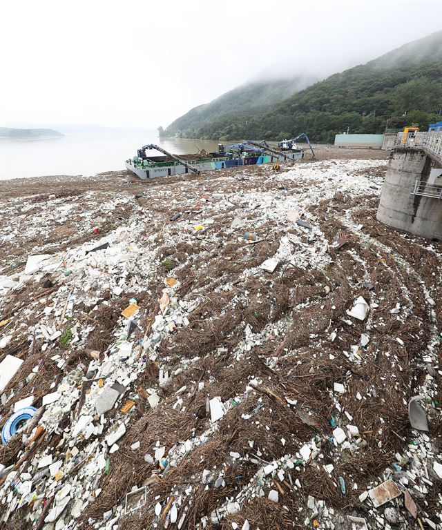 18일 오전 경기도 하남시 팔당댐에서 한국수력원자력 팔당사업소와 경기도수자원본부 관계자들이 크레인과 바지선을 이용해 최근 많은 비로 상류에서 떠내려온 쓰레기를 치우고 있다. 2017.7.18 하남=연합뉴스