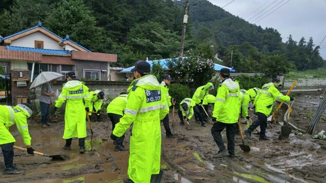 18일 청주 상당경찰서 직원들이 상당구 월오동의 피해 주택에서 복구작업을 하며 구슬땀을 흘리고 있다. 뉴시스