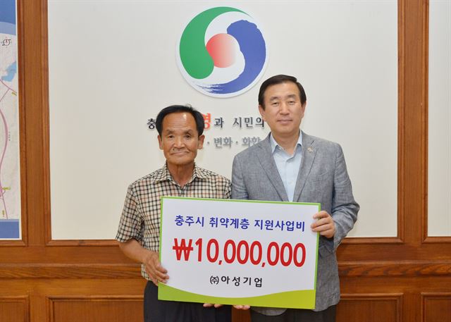 이진용(왼쪽)씨가 18일 오후 조길형 충주시장을 만나 1,000만원을 기탁한 뒤 기념촬영을 하고 있다. 충주시 제공