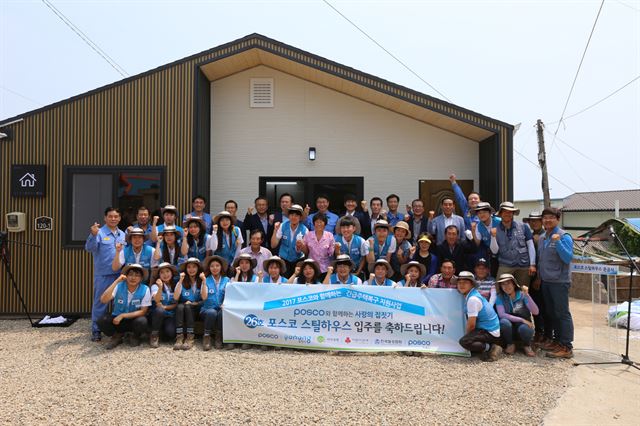 스틸하우스를 건축한 포스코 대학생 봉사단 '비욘드' 단원들과 관계자들이 포항 남구 구룡포 스틸하우스 앞에서 기념촬영하고 있다.